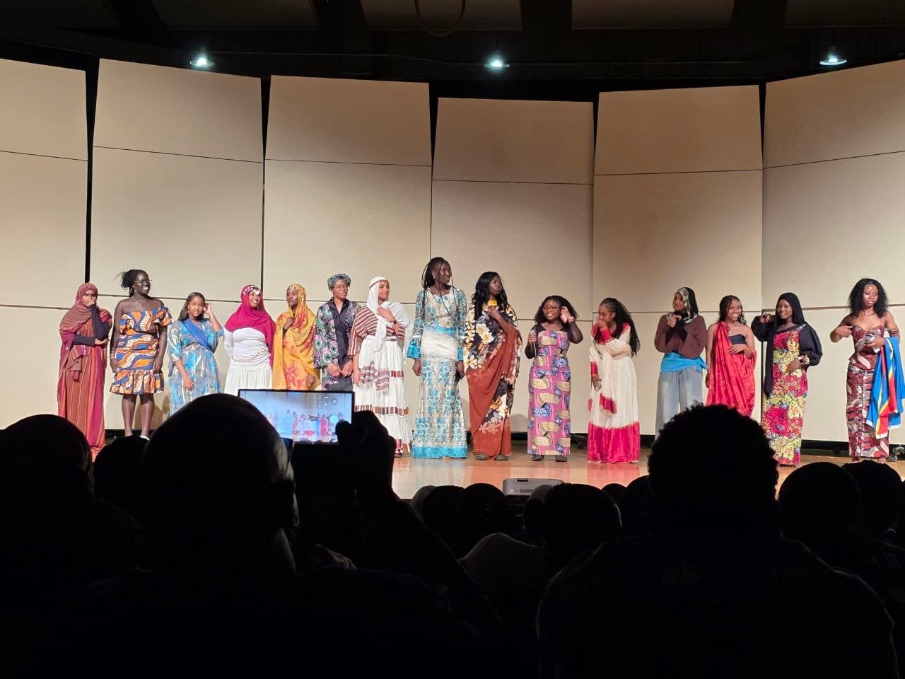 Students in colorful cultural attire lined up on stage during A Night in Africa